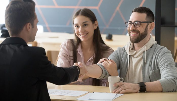 Happy,Millennial,Couple,Handshaking,Realtor,Making,Real,Estate,Deal,,Smiling